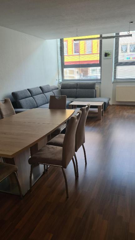 sala de estar con mesa, sillas y sofá en Familien-Ferienwohnung Fiwa FeWo-4, en Pirmasens