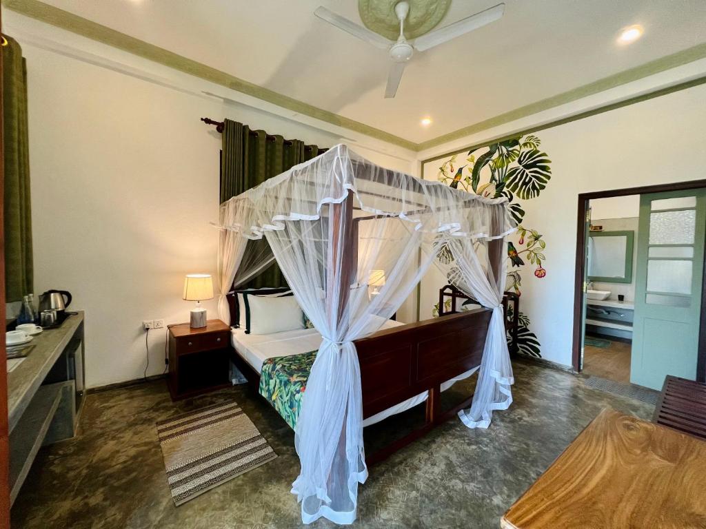 a bedroom with a bed with a canopy at Green Escape Unawatuna in Unawatuna