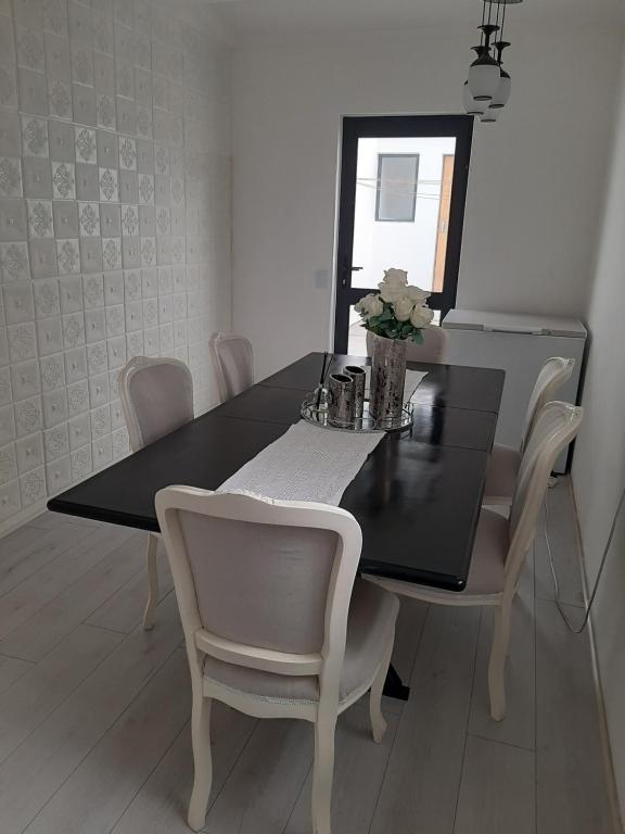 czarny stół jadalny z białymi krzesłami i lustrem w obiekcie White house w Kapsztadzie