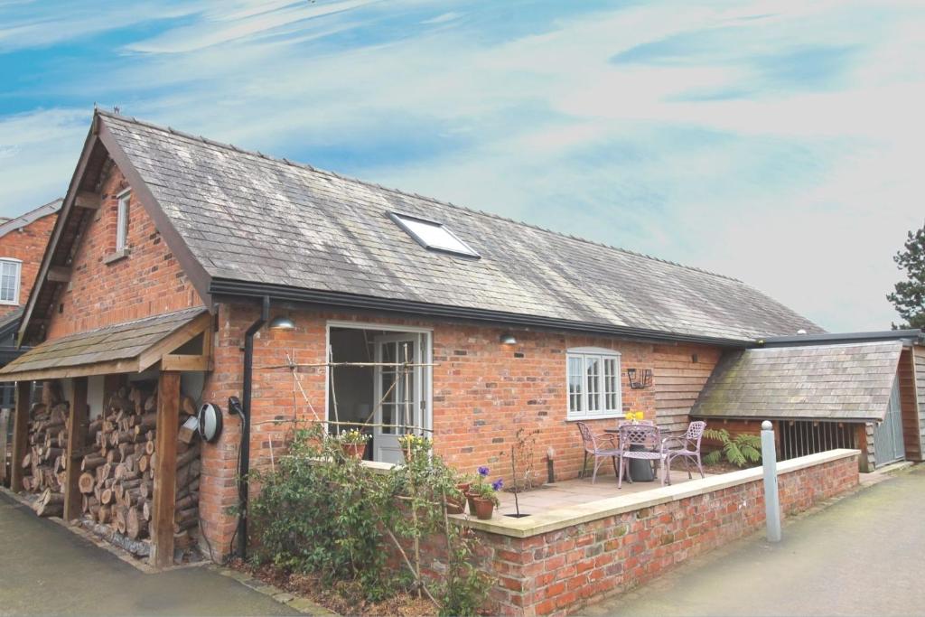 a brick house with a porch and a patio at The Hayloft - Cheshire in Crewe