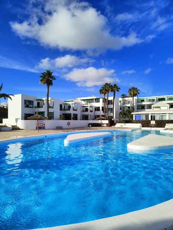 duży basen przed budynkiem w obiekcie Ailana Suite Vistas al Mar y con Piscina w Costa Teguise