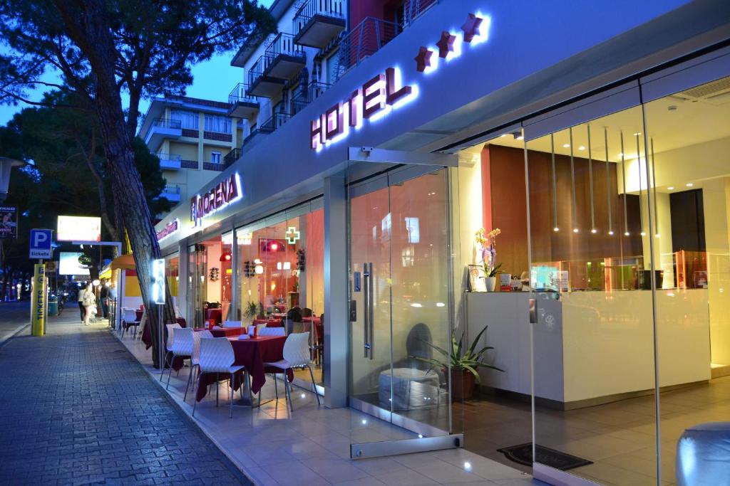 restauracja ze stołami i krzesłami przed sklepem w obiekcie Hotel Morena w mieście Lido di Jesolo