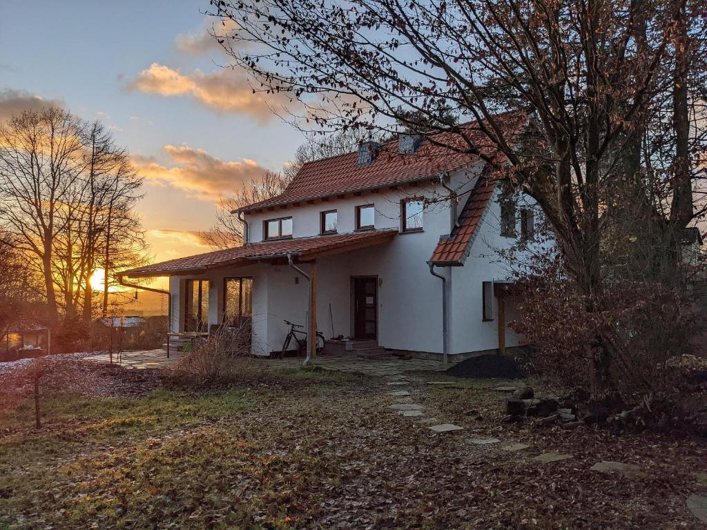 a small white house with a sunset in the background at Ahlberg Ferienhaus in Mariendorf