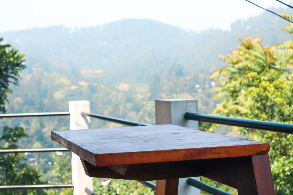 einen Holztisch auf dem Balkon mit Aussicht in der Unterkunft Duet Hearts in Ella