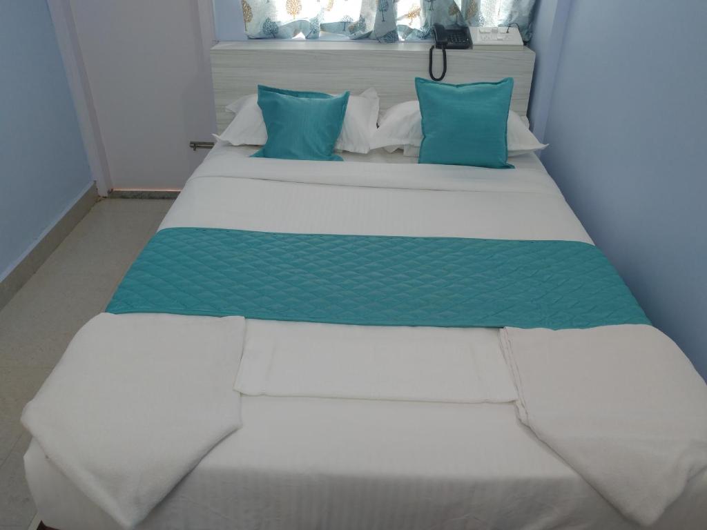 Postel nebo postele na pokoji v ubytování Sai Inn Mysore