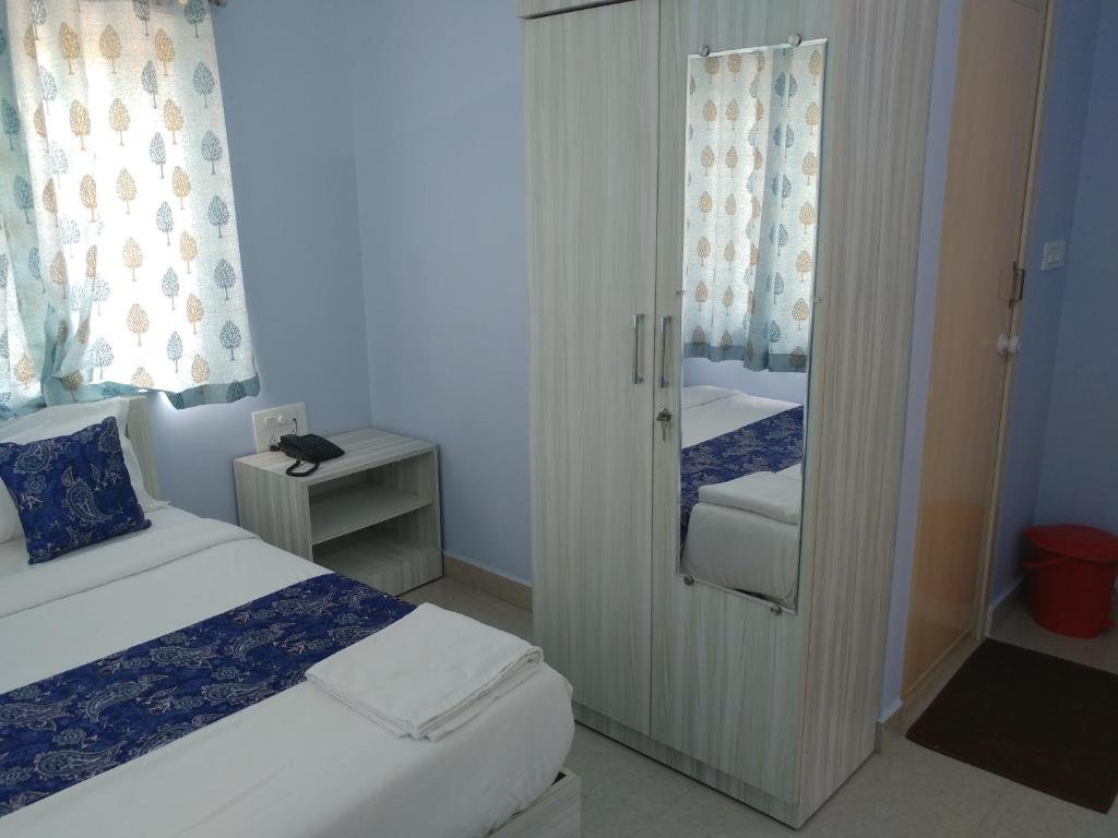 Postel nebo postele na pokoji v ubytování Sai Inn Mysore