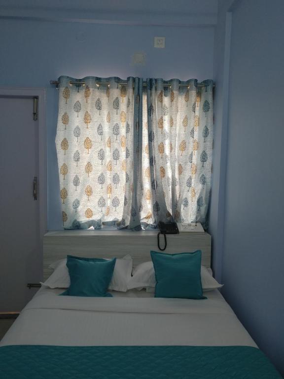 Postel nebo postele na pokoji v ubytování Sai Inn Mysore