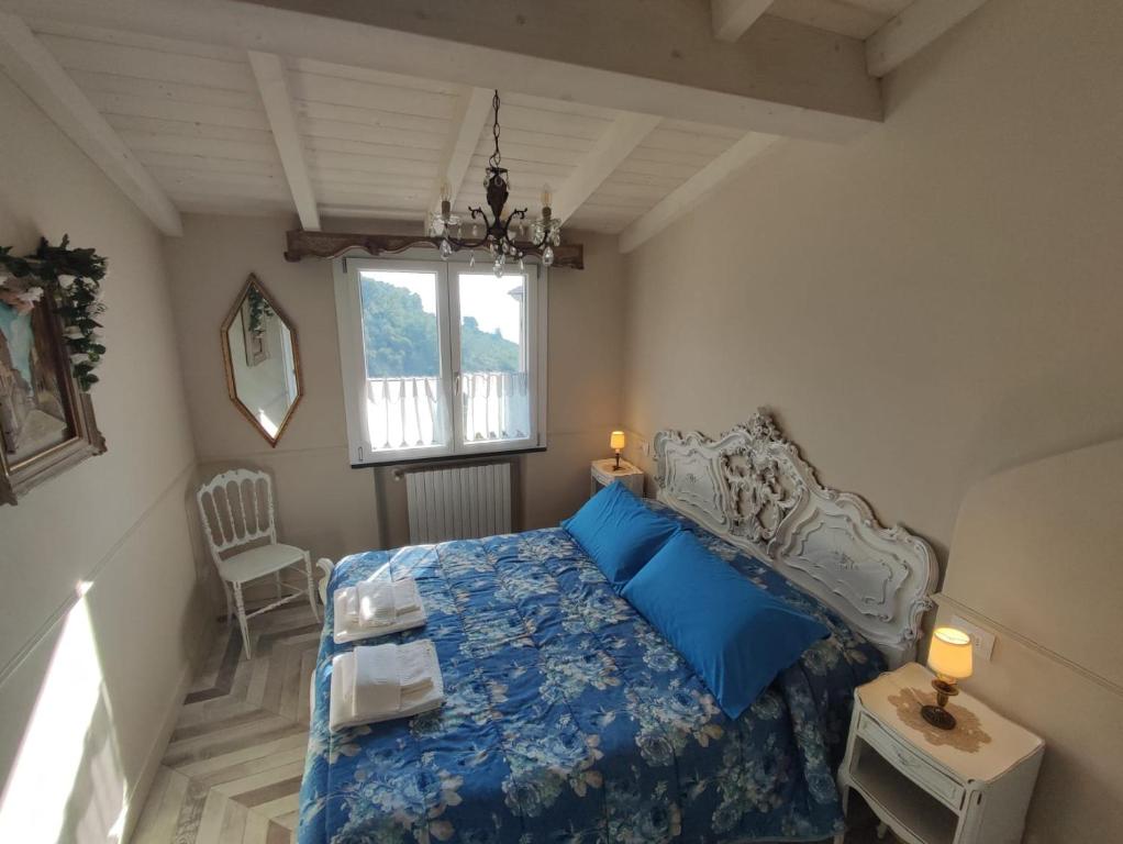 1 dormitorio con cama con sábanas azules y ventana en Florinda Lemon's Suite, en Cervo