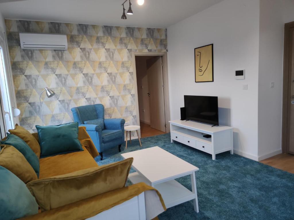 a living room with a couch and a tv at Blue Apartment Riverside in Podgorica