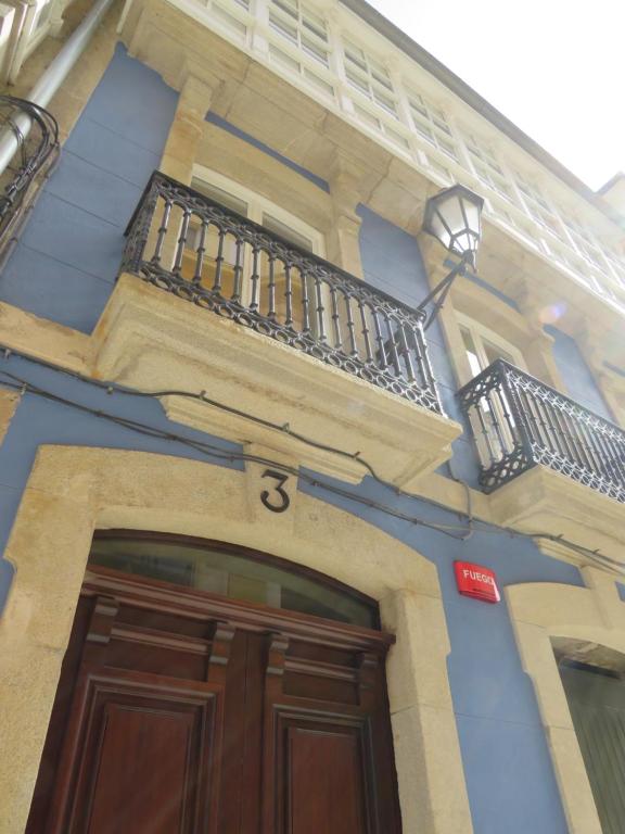 a blue building with a wooden door and a balcony at APARTAMENTOS ARMANYA 3 in Lugo