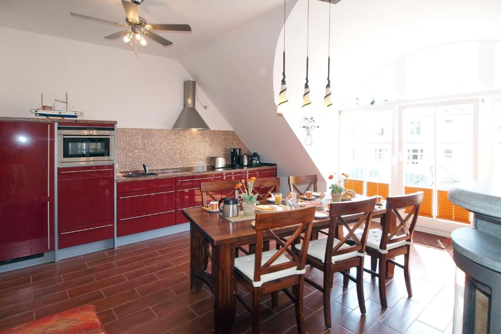 una cucina con un tavolo e sedie in legno in una stanza di Strandpalais Wohnung 11b a Kühlungsborn