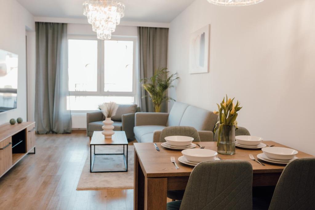 a living room with a dining room table and a couch at Złote Apartamenty 58 in Legnica