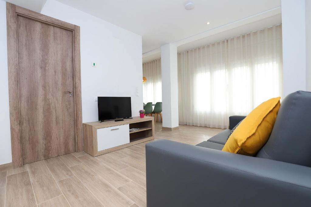 een woonkamer met een bank en een televisie bij APARTAMENTS AGNETA - Rem in Cambrils