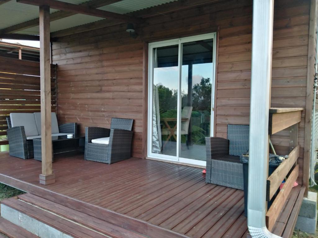 une terrasse en bois avec des chaises et une table. dans l'établissement Domaine Decotte bungalow, à Sainte-Suzanne