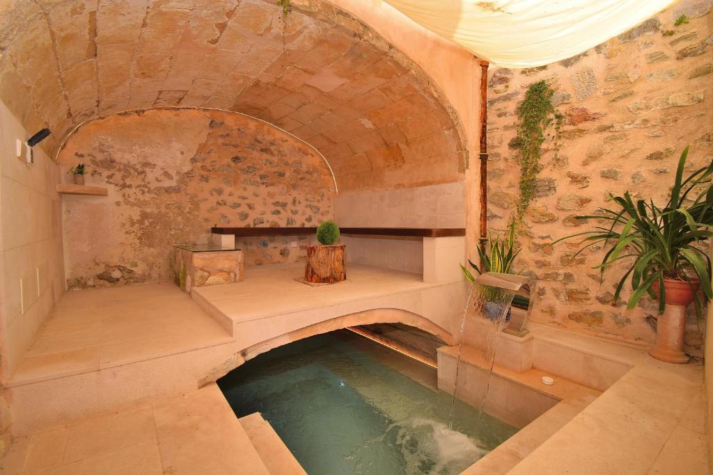 a pool of water in a room with a stone wall at Casa Alcariot 252 by Mallorca Charme in Artá
