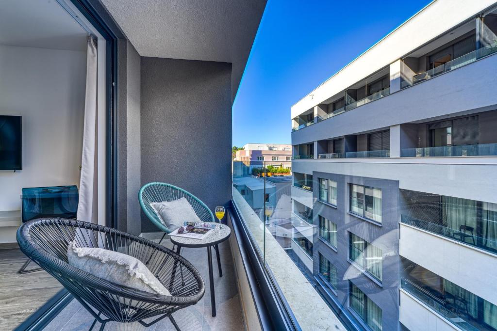 a balcony with two chairs and a table on a building at Apartments Hica in Dubrovnik