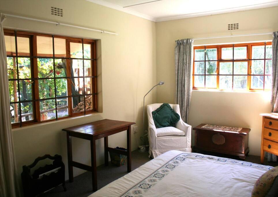 a bedroom with a bed and a desk and windows at 34 Steyn Street, Barrydale in Barrydale