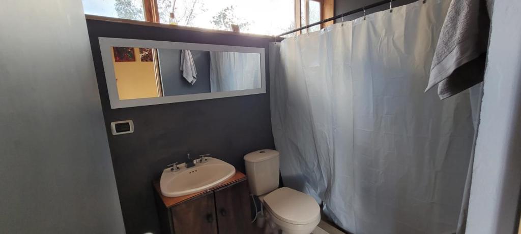 a bathroom with a sink and a toilet and a mirror at Villa Vista in Guatavita