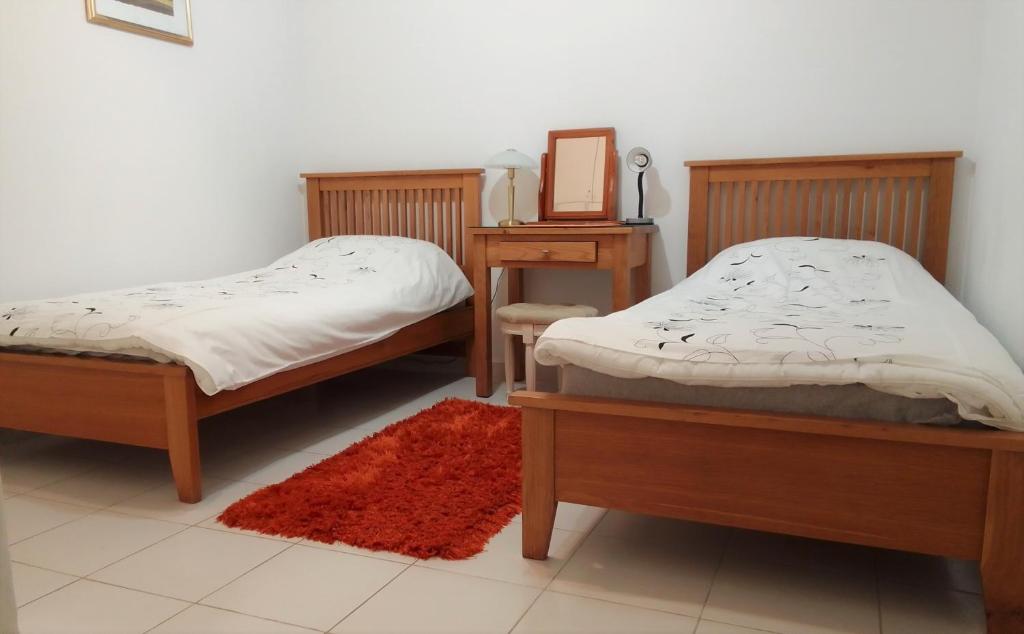 two beds in a room with a table and a mirror at Aphrodite Springs in Paphos City