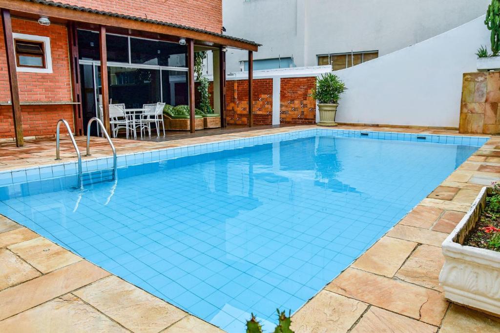 ein Pool mit blauen Fliesen in einem Haus in der Unterkunft Casa beira mar na Praia da Enseada no Guaruja SP in Guarujá