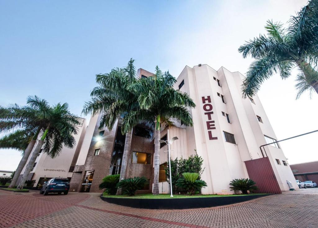 un edificio con palmeras delante en London Hotel, en Londrina