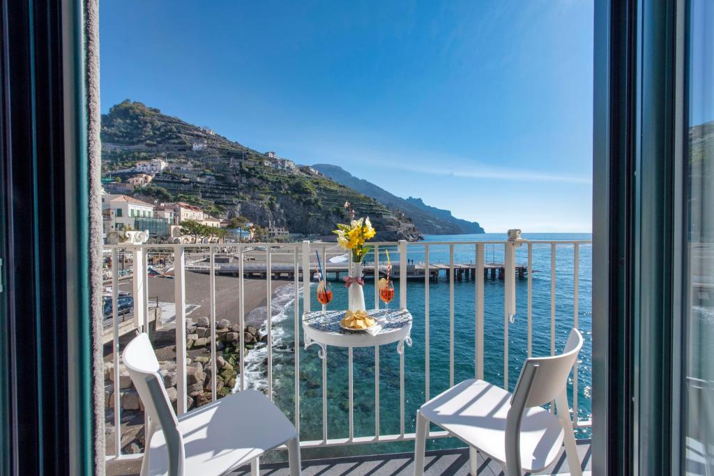 d'un balcon avec une table et des chaises et une vue sur l'océan. dans l'établissement IL Nido Del Gabbiano, à Minori