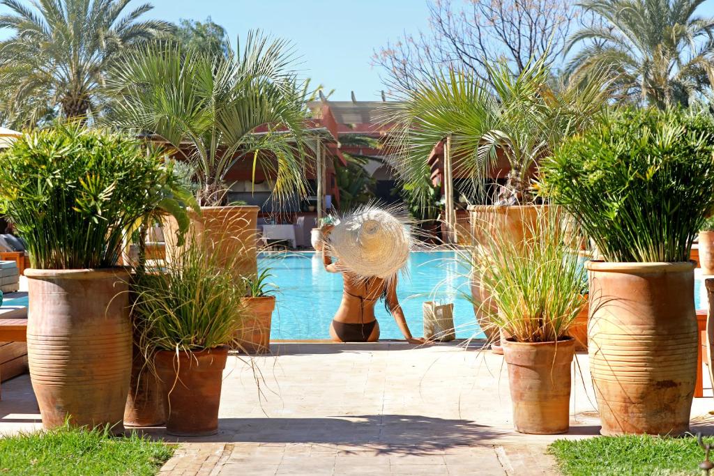 a woman in a swimming pool with a fountain at Domaine Des Remparts Hotel &amp; Spa in Marrakech