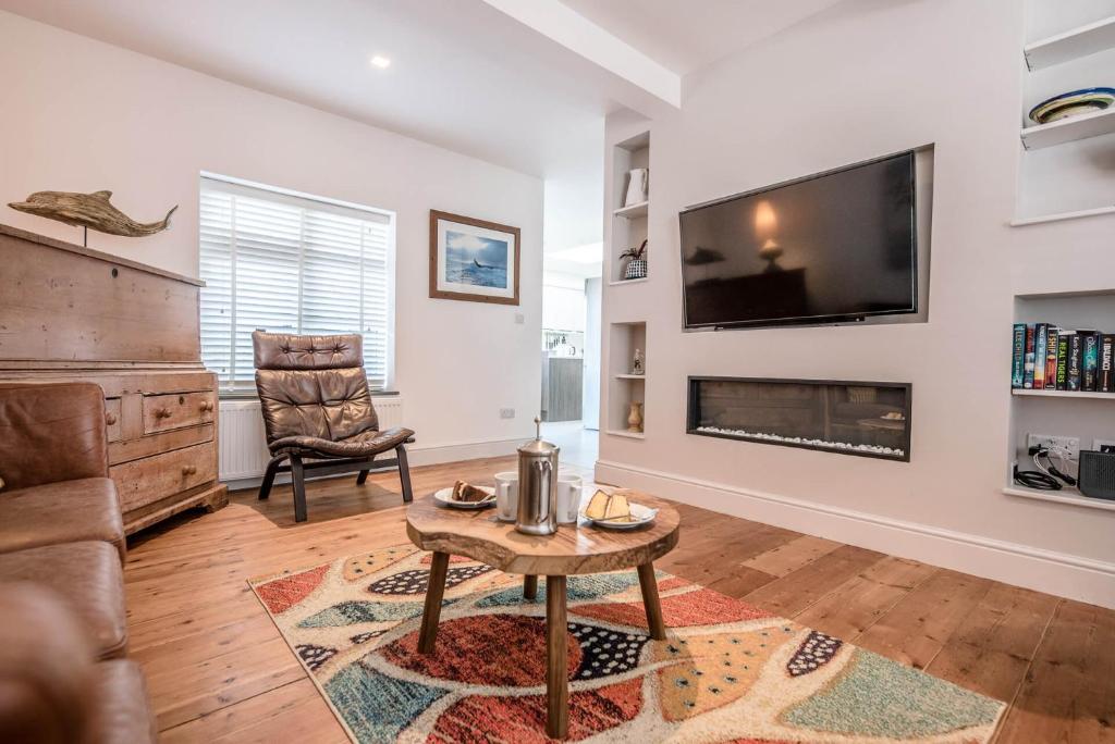 a living room with a fireplace and a tv at Swifts in Southwold