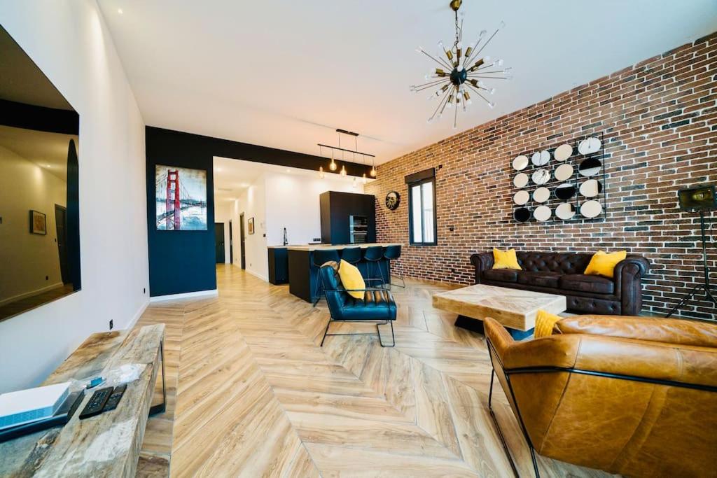 - un salon avec des canapés et un mur en briques dans l'établissement Appartement d’exception en centre ville sur quai, à Sète
