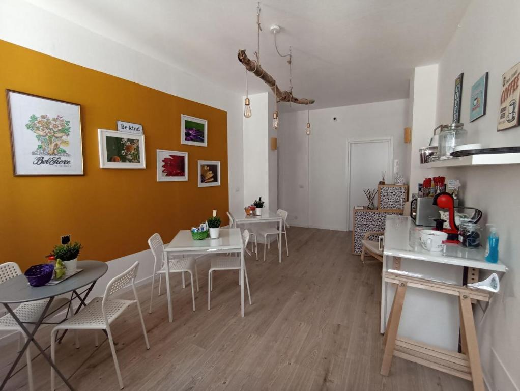 B&B Bel Fiore في أنكونا: غرفة معيشة مع طاولات بيضاء وكراسي بيضاء