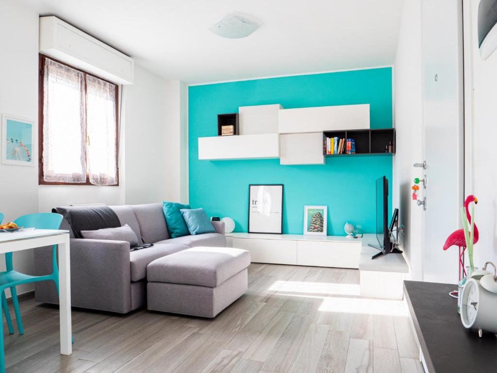 - un salon avec un canapé et un mur bleu dans l'établissement The Best Rent - Apartment near Arco della Pace, à Milan