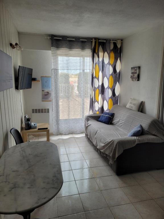 1 dormitorio con cama, mesa y ventana en Location résidence Océane en Soulac-sur-Mer