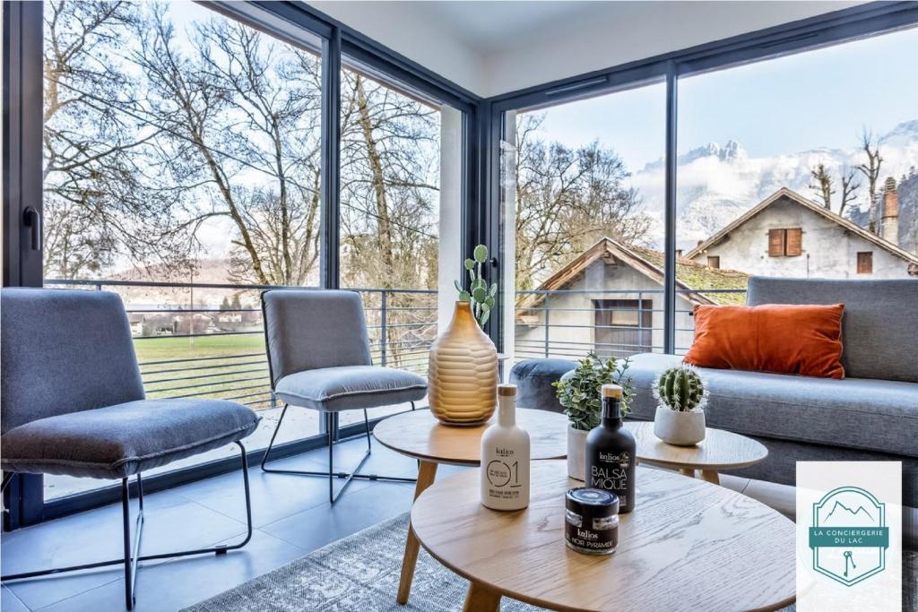 sala de estar con sofá, sillas y mesa en Villa on the shores of Lake Annecy en Duingt