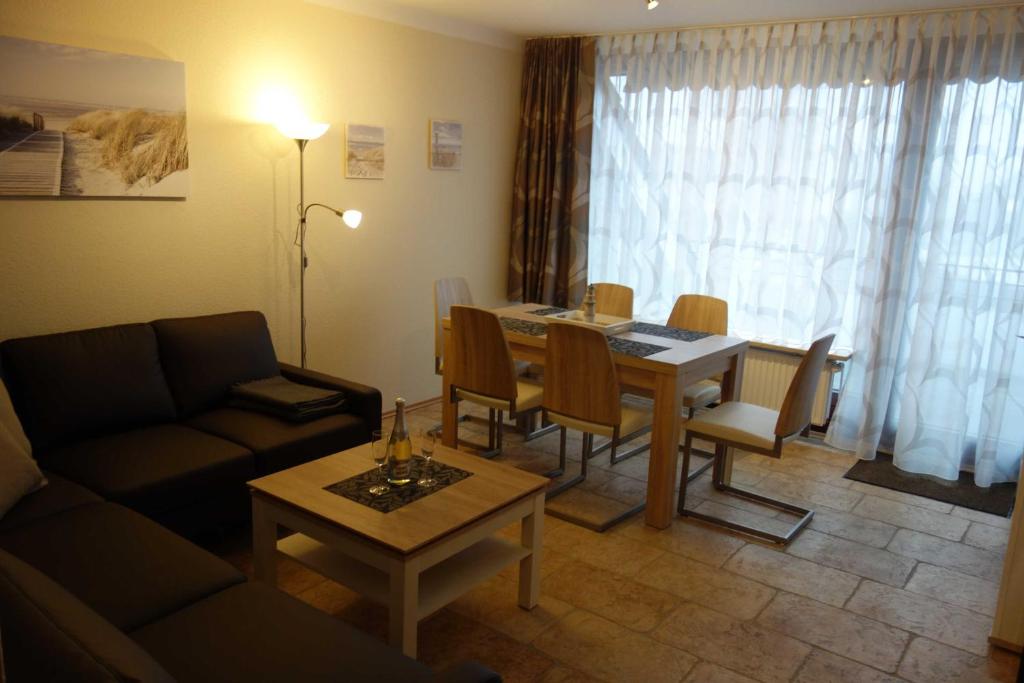 ein Wohnzimmer mit einem Tisch und einem Sofa in der Unterkunft MEI27a Ferienwohnung Ostseetraum in Niendorf