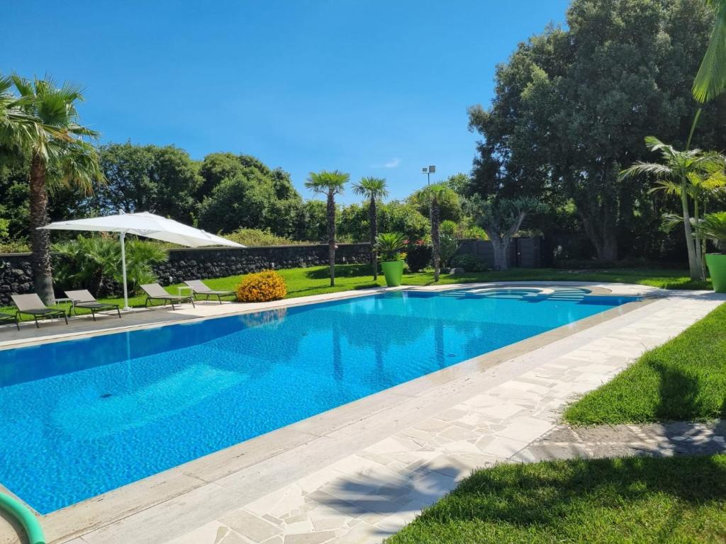 a swimming pool with blue water in a yard at Villa Arianna in Acireale