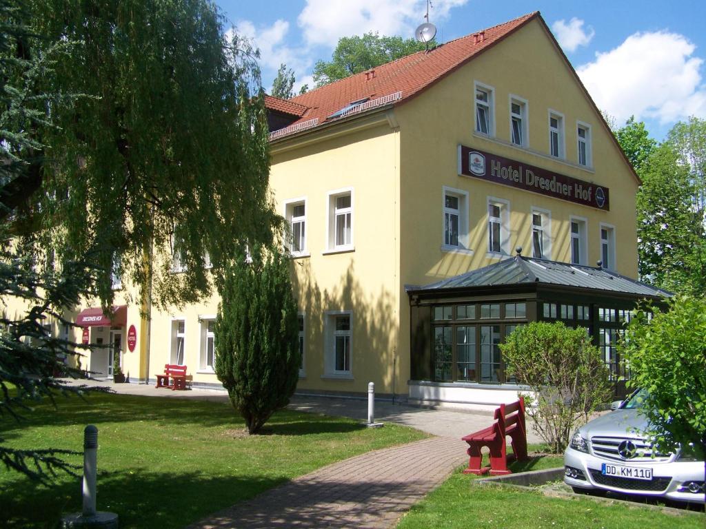 ein großes gelbes Gebäude mit einem Schild drauf in der Unterkunft Dresdner Hof in Zittau