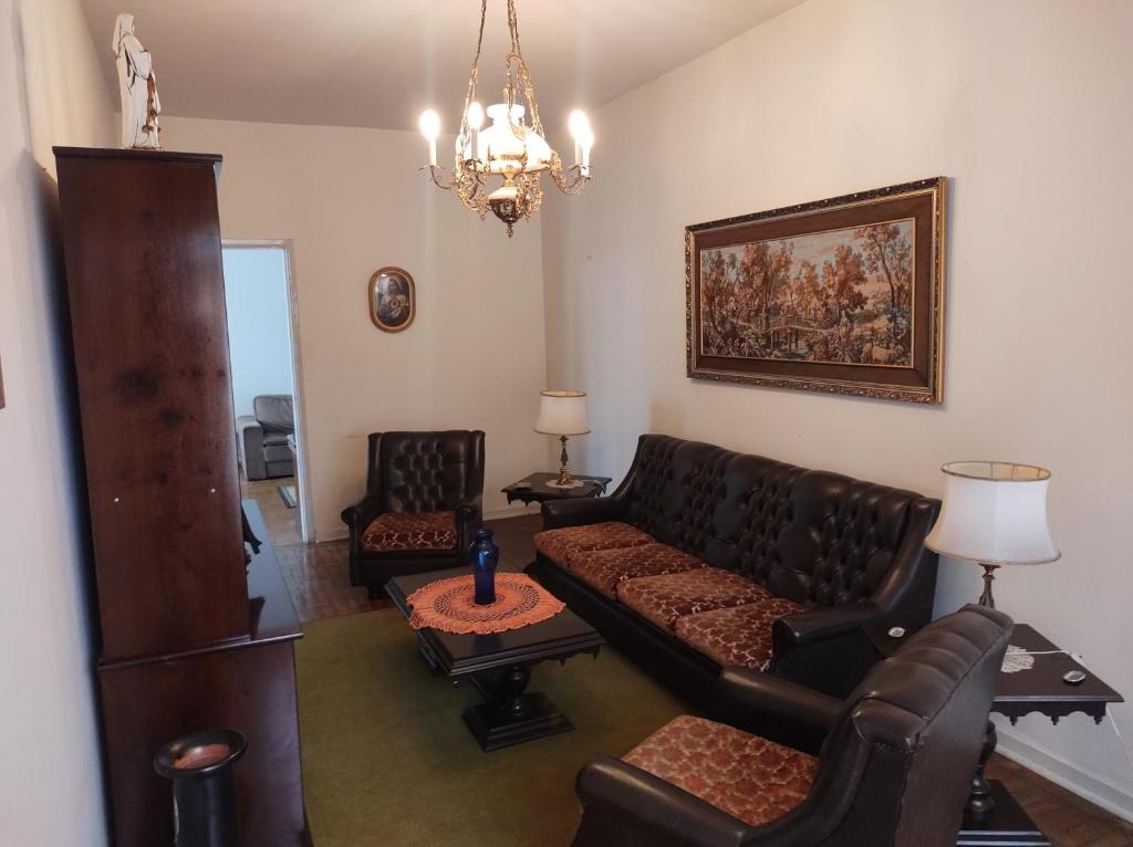 a living room with a couch and chairs and a chandelier at Casa ótima e localização excelente em Aparecida-SP in Aparecida