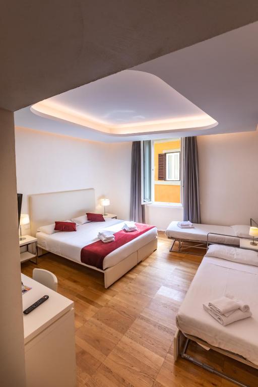 pokój hotelowy z 2 łóżkami i kanapą w obiekcie Trevi Elite Rome w Rzymie