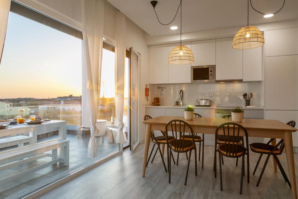 a kitchen with a table and chairs and a large window at Sunny Penthouse in Ferrel