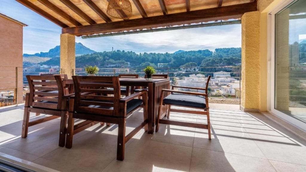 a dining room with a table and chairs on a balcony at Apartamento Guillem in Cala de Sant Vicent