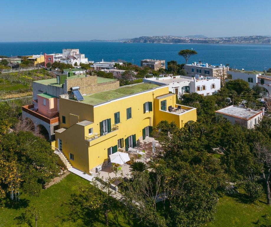 an aerial view of a yellow house with the ocean in the background at Villa Caterina b&b in Procida