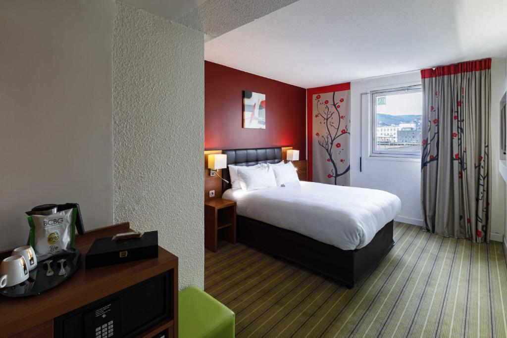 Säng eller sängar i ett rum på Holiday Inn Clermont Ferrand Centre, an IHG Hotel