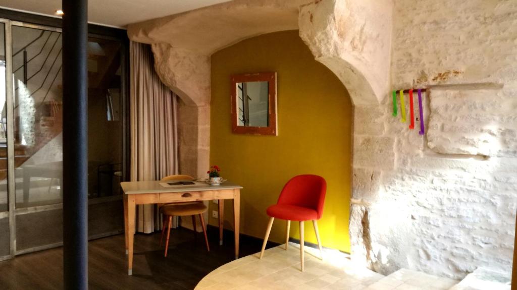 a dining room with a table and a red chair at L'antre ami in Savigny-lès-Beaune