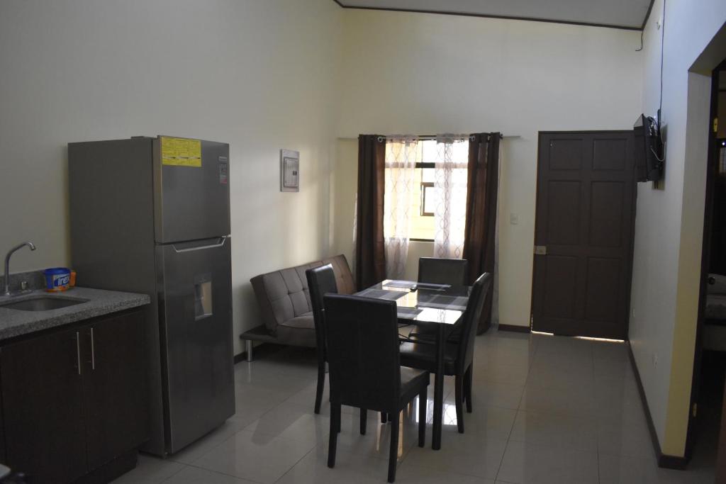 eine Küche mit einem Tisch und Stühlen sowie einem Kühlschrank in der Unterkunft Apartamentos Guzmán in Arenilla