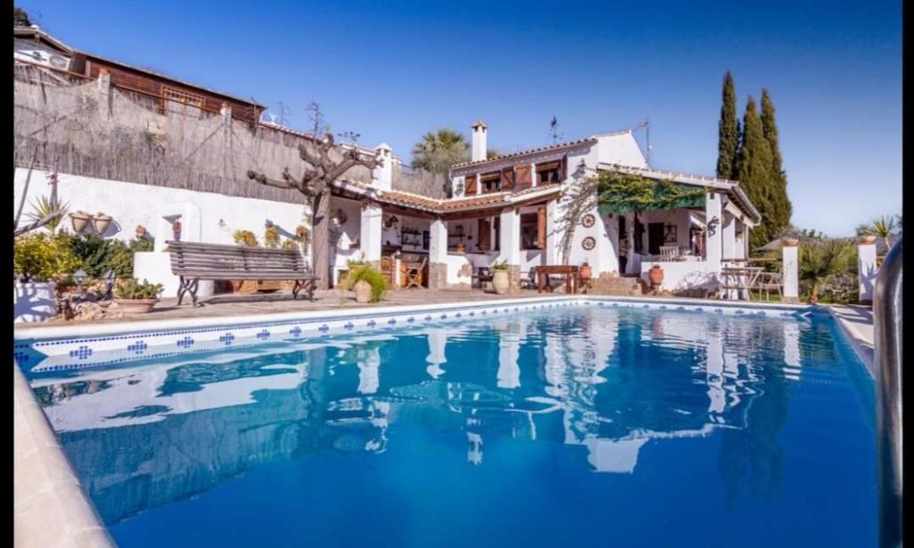 a large swimming pool in front of a house at Casa la serena in Iznájar