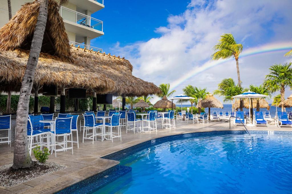 een zwembad met stoelen en parasols en een regenboog bij Reefhouse Resort and Marina in Key Largo