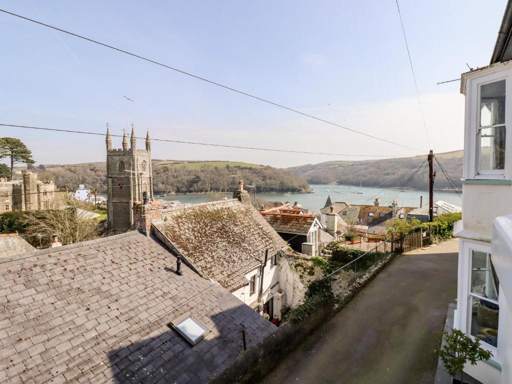 a view of a town with a church and a river at Driftwood in Fowey