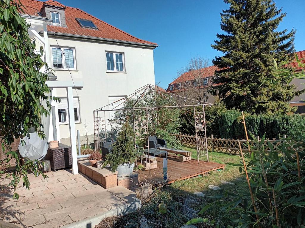 een tuin met een kas voor een huis bij Ferienwohnung NaumburgLiebe in Naumburg