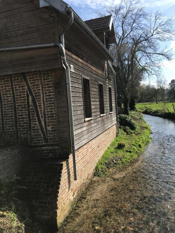 a building next to a river next to a house at Maison au bord de riviere , proche de la mer- spa semi rigide plein air en option in Bacqueville-en-Caux