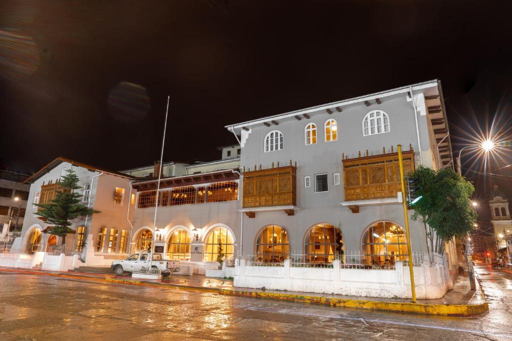 un gran edificio blanco con ventanas por la noche en Hotel de Turistas Huancayo - Hotel Asociado Casa Andina, en Huancayo